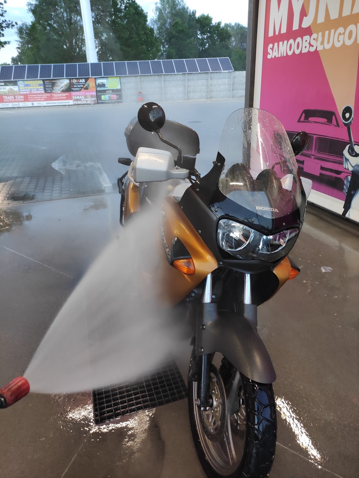 Motocykl Honda w trakcie mycia lancą wodną na stanowisku myjni samoobsługowej Jedynka.